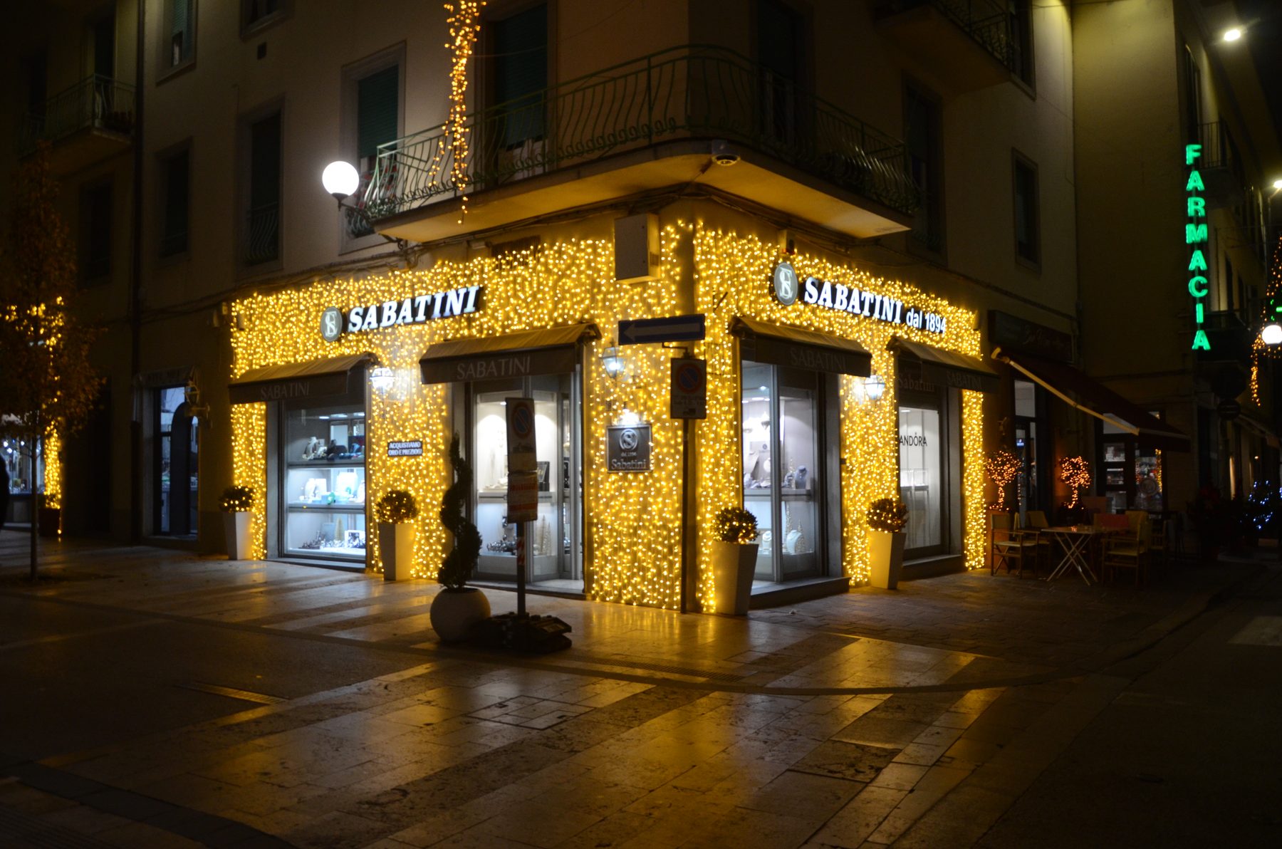 Facciata di una gioielleria illuminata con luminarie natalizie